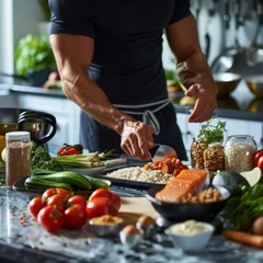 Fotobehang A muscular man in a fitted black shirt prepares a nutritious meal in a modern kitchen, surrounded by fresh produce and grains. © Zhanna