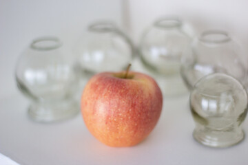Glass jars for hijama and apple on a white background. Bloodletting. Sunnah treatment. Islam.