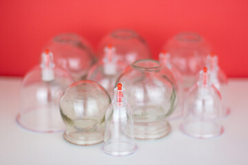 Glass jars for hijama and an apple on a red background. Bloodletting. Sunnah treatment. Islam.