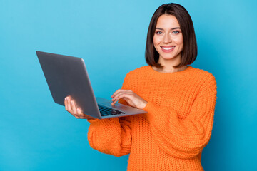 Portrait of attractive cheerful skilled girl using laptop creating project isolated over bright...