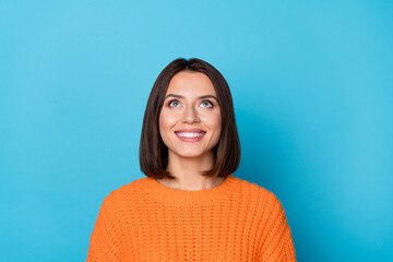 Portrait of attractive curious cheerful brown-haired girl looking up copy empty space clue isolated over bright blue color background - 765097881