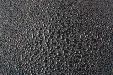 water droplets on black surface, abstract texture of wet drops condensation with reflective lights...
