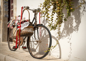Antique bicycle with basket.. Somewhere on an Italian avenue. - obrazy, fototapety, plakaty