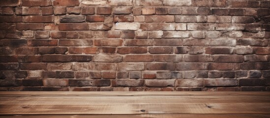 A wooden table with no items on it positioned in front of a sturdy brick wall - obrazy, fototapety, plakaty