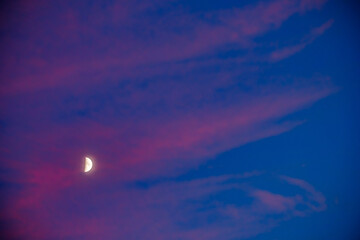 Moon at sunset between pink clouds in Alhambra