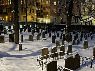 Beautiful moody cityscape night scene of snow covered burial place in Stockholm.