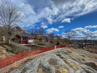 Landscape view of a little red wooden cottage high up on a small local mountain.