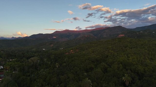 Paisaje a&eacute;reo de monta&ntilde;as y bosque h&uacute;medo tropical,  en un atardecer con algunas viviendas del pueblo de Melgar -Tolima en Colombia