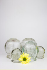 Fototapeta na wymiar Glass jars for hijama. Yellow flowers. Bloodletting. Sunnah treatment. Islam.