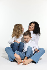 Little children with their mother sitting together on white background