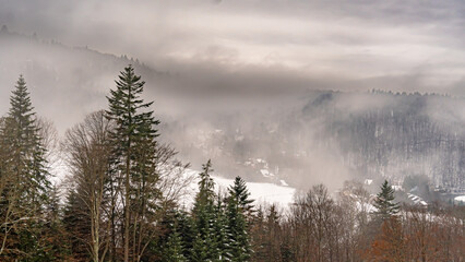 Aerial view of the mountains in the fog in the Poprad Landscape Park on a winter morning.