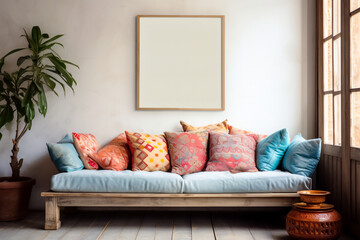 Cozy bohemian eco living room with wooden window, patterned multi-colored pillows on the soft sofa and framed mock up on the light wall. Modern interior design with copy space