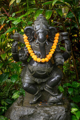 Beautifully adorned Hindu Statuary decorated with flowers and offerings. Set amongst lush tropical gardens these statues provide solace and peace to Hindu worshipers. - 765111028