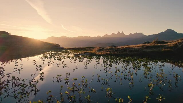 Sunrise shines over Lac Guichard with Arves massif and lake reflection in autumn at Aiguilles d'Arves, French Alps, France