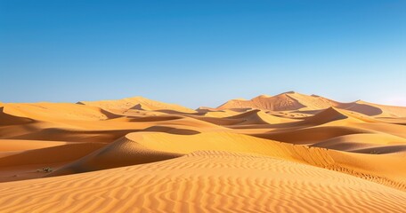 Fototapeta na wymiar Vast desert dunes under blue sky at sunset - The vast expanse of desert dunes is beautifully captured under a striking blue sky as the sun sets, creating a peaceful scene