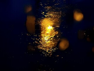 La luce si specchia una pozza di acqua durante la pioggia.