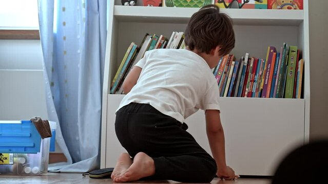 Playtime’s Over - Young Boy Reluctantly Tidies Up Toys In Room