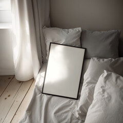 Poster frame mockup (DinA) in bedroom interior. A poster frame leans against the pillows on the bed in a bedroom with minimalist decor and natural light streaming in through the window.
