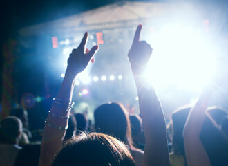 Crowd cheering and watching a band on stage, blurred motion, shallow DOF.