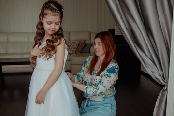 Mom and daughter trying on a beautiful white dress