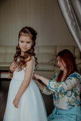 Mom and daughter trying on a beautiful white dress