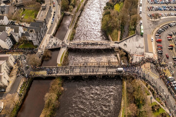 Saint Patrick parade in Galway. Crossing Salmon Weir Bridge
Wide angle, top down aerial view.