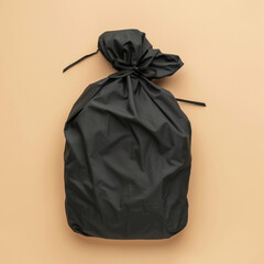 A black storage bag lying flat on the ground, solid beige background, full top view, top view, black fabric storage bag, elastic storage bag