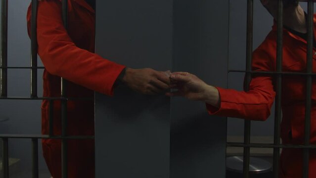 Close up of prisoners passing contraband in jail