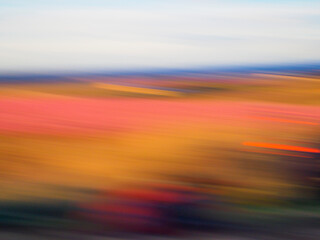 Abstract landscape of a meadow with trees in spring. Totally out of focus.