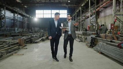 Concept of industrial production in the manufacturing factory in front of the camera walking main manager and engineer and discussing about the future plan of production - Powered by Adobe