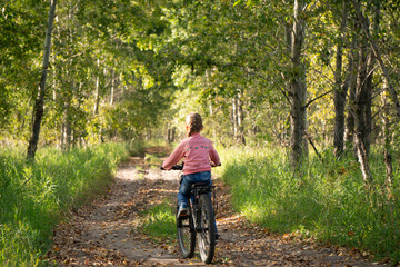 girl rides a children's bike, summer, cycling, sports for children, sports for children, cycling, summer walk, childhood, happiness, smile, joy, happy, joyful, hairstyle