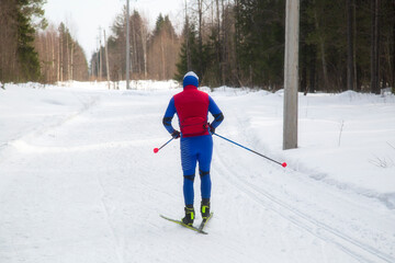 People ski in winter on a ski track through a winter forest.Cross Country skiing.