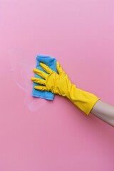 Person in yellow gloves cleaning pink surface, ideal for cleaning services advertisement