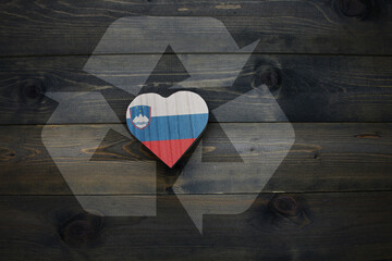 wooden heart with national flag of slovenia near reduce, reuse and recycle sing on the wooden...
