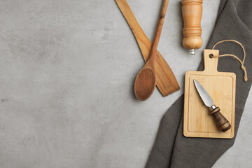 Various wooden and bamboo kitchen utensils are laid out on a pastel background. top view. flat lay