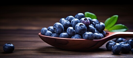 Fresh blueberries in a wooden spoon