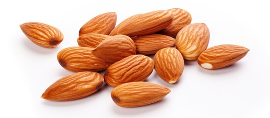 A close up of a pile of almonds on a white surface