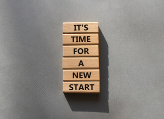 Time for a new start symbol. Wooden blocks with words Time for a new start. Beautiful grey...