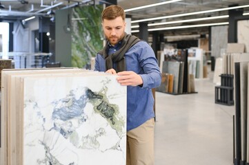 Middle age man choosing ceramic tiles and utensils for his home bathroom