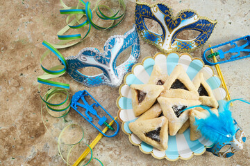 Jewish holiday Purim background with hamantaschen or hamans ears cookies, carnival mask and noisemaker - 765198646