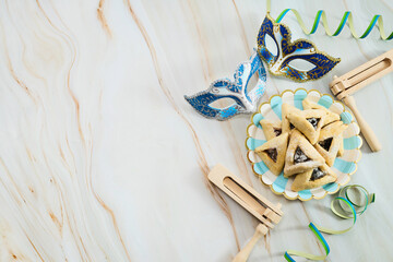 Jewish holiday Purim background with hamantaschen or hamans ears cookies, carnival mask and noisemaker - 765198877