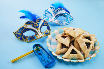 Jewish holiday Purim background with hamantaschen or hamans ears cookies, carnival mask and noisemaker - 765199272