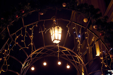 Christmas street light adorning archway in New Year night imparts cozy ambiance to nocturnal scene,...