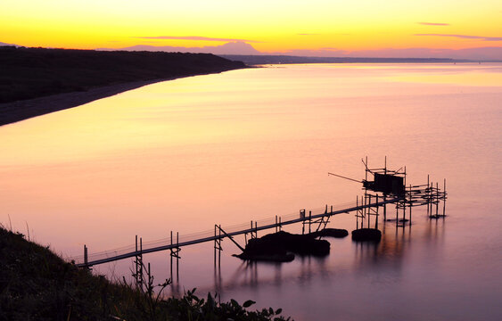 Meraviglioso e colorato tramonto sul mare a primavera con montagna sullo sfondo e macchina da pesca. punta aderci al tramonto con sullo sfondo il corno grande. vasto trabocco e corno grande