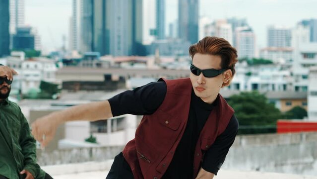 Professional hispanic break dancer practice B boy dance while multicultural friends at roof top. Young modern dancing group doing hip hop movement. Style,fashion,action. Outdoor sport 2024. hiphop.
