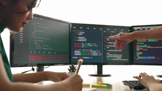 Slow motion back end software developer engineer for computer programming working together on debugging writing computing code, solving complex algorithms display on monitor in office. Burgeoning