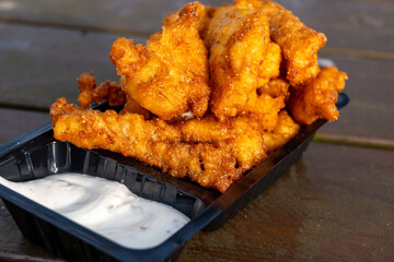 Outdoor eating of diep-fried cod fish pieces served with remoulade sauce, Dutch street food