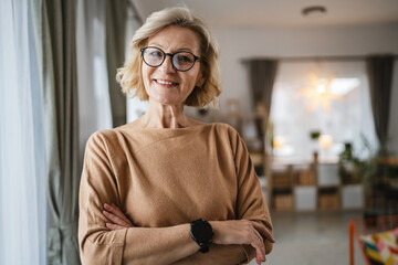 Portrait of one mature blonde caucasian woman with eyeglasses at home