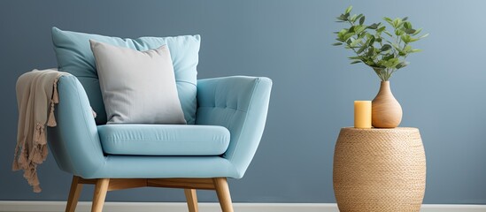 A blue chair with a pillow on it is placed next to a wooden table adorned with candles. The furniture arrangement enhances the interior design of the room, combining comfort and style