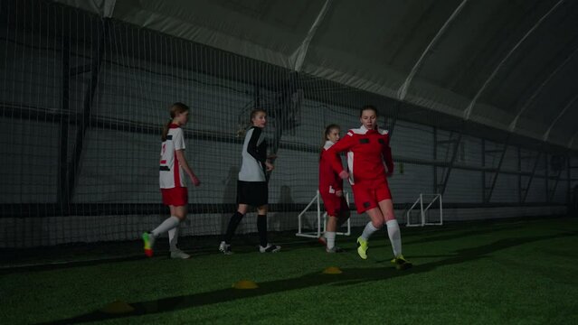 Athletic Girls Training On Soccer Field Indoors, Workout Of Football Children Team In Indoors Arena